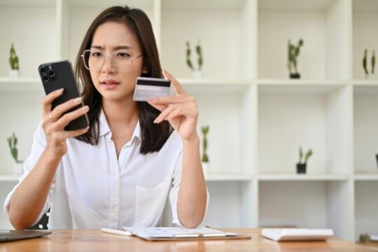 Woman holding a smartphone and credit card