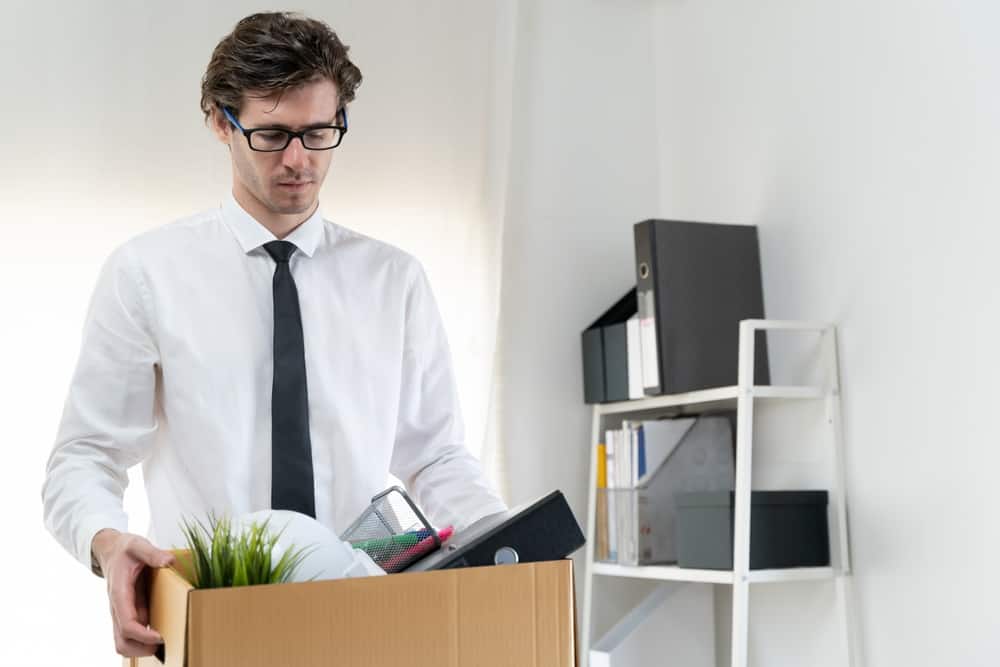 Man holding a box of office items after being fired