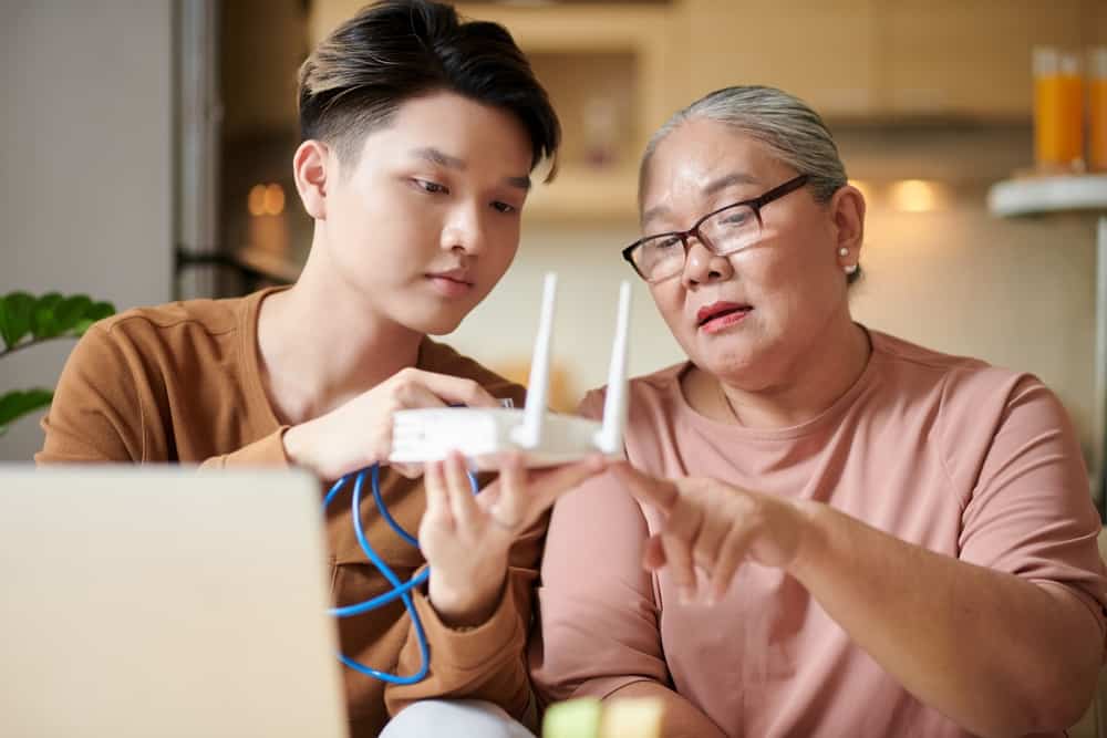 A young man explaining to an older woman how to set up a router