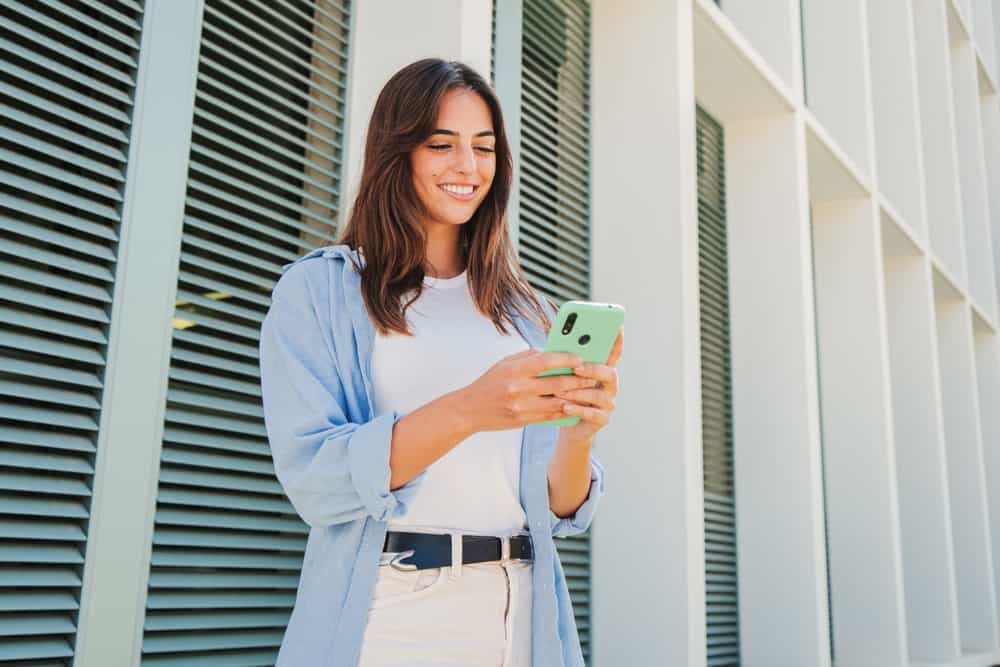 Young woman smiling while holding a smartphone