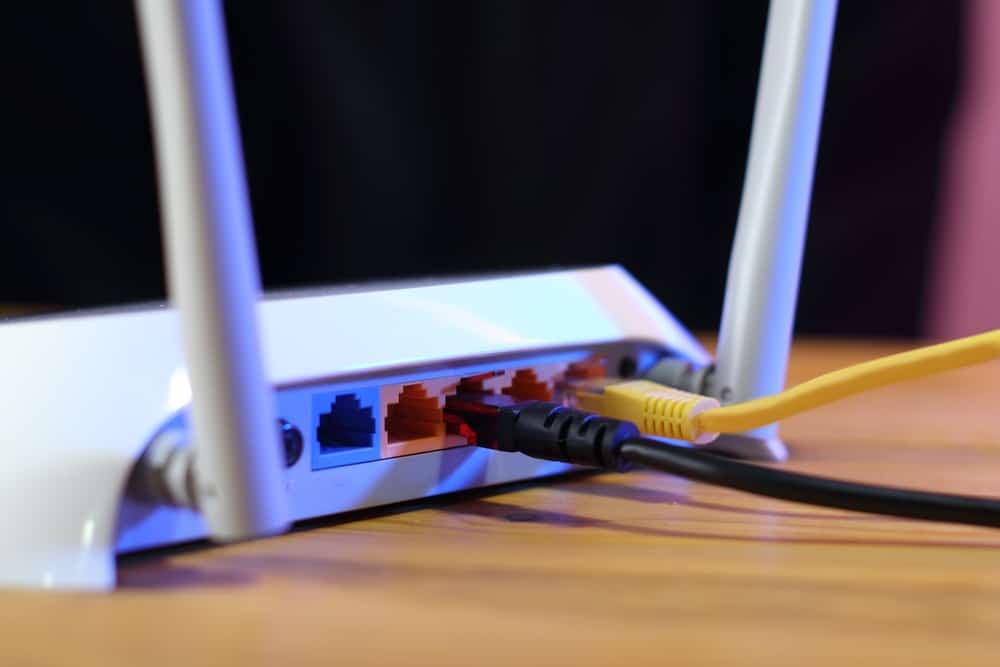 The backside of a router with cables plugged in