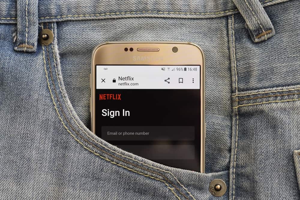 A smartphone tucked in a pocket with the Netflix login screen shown