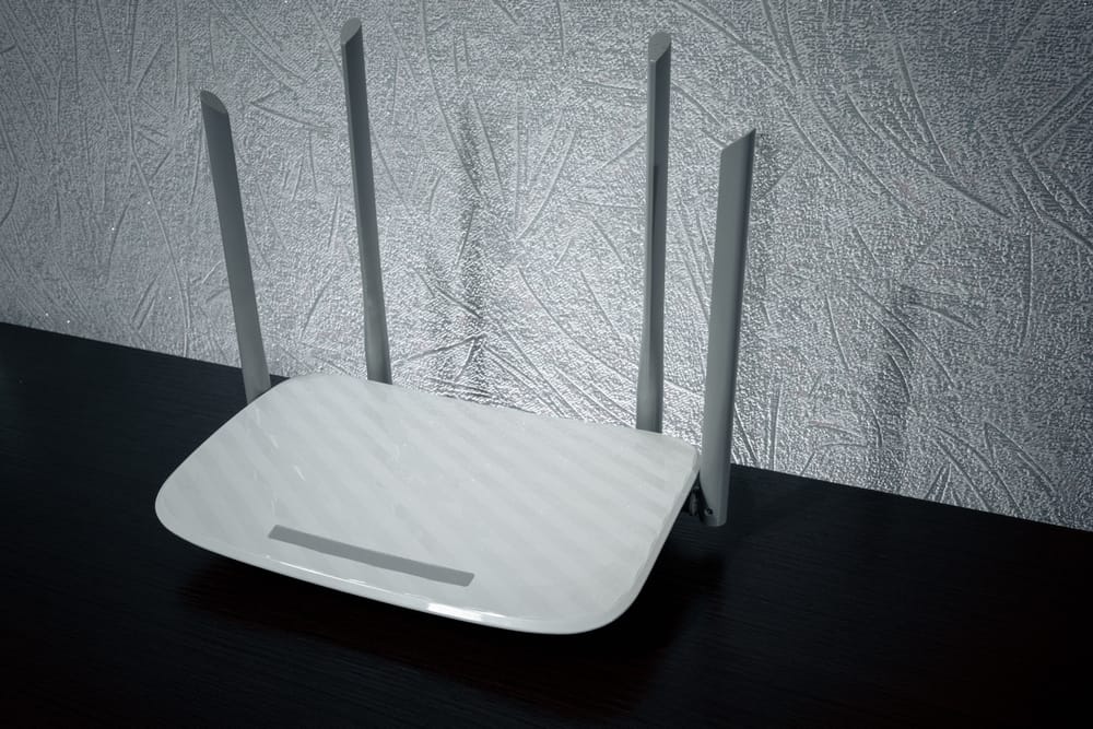 A generic white router on a black wooden table