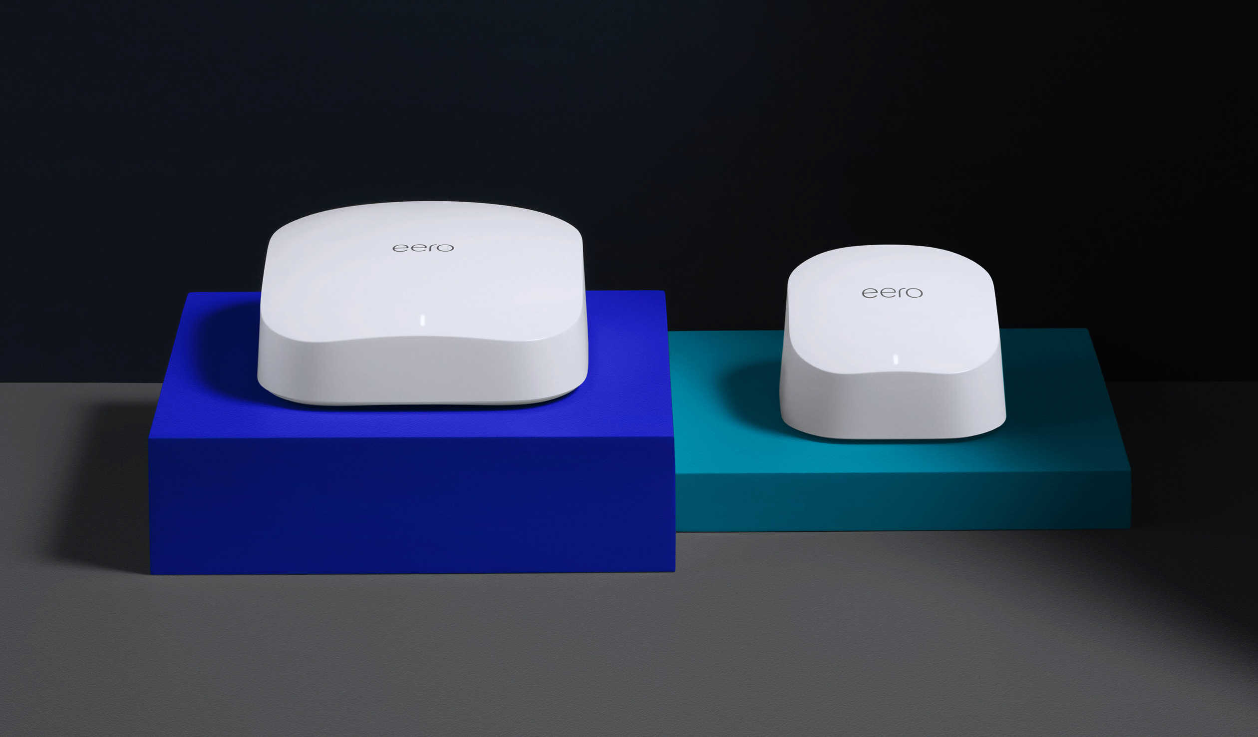 Two white eero devices resting on colored risers.