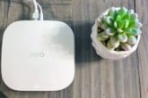 An eero Pro 6 device sitting next to a succulent plant on a TV stand.