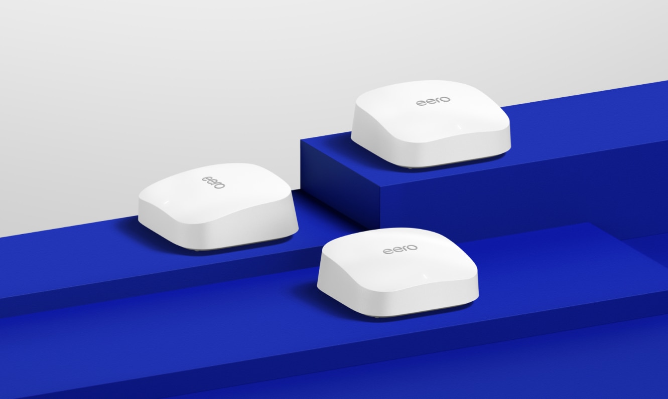 Three white eero Pro 6E devices displayed on dark blue risers of varying heights.