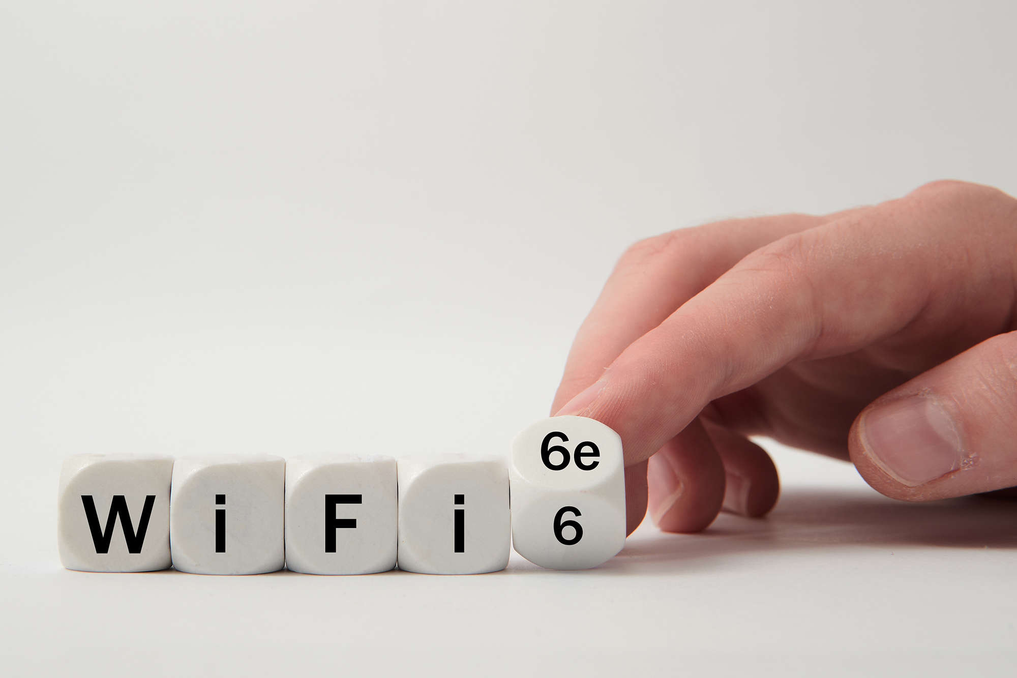 Person flipping a die to 6e in a collection of dice that read WiFi 6 