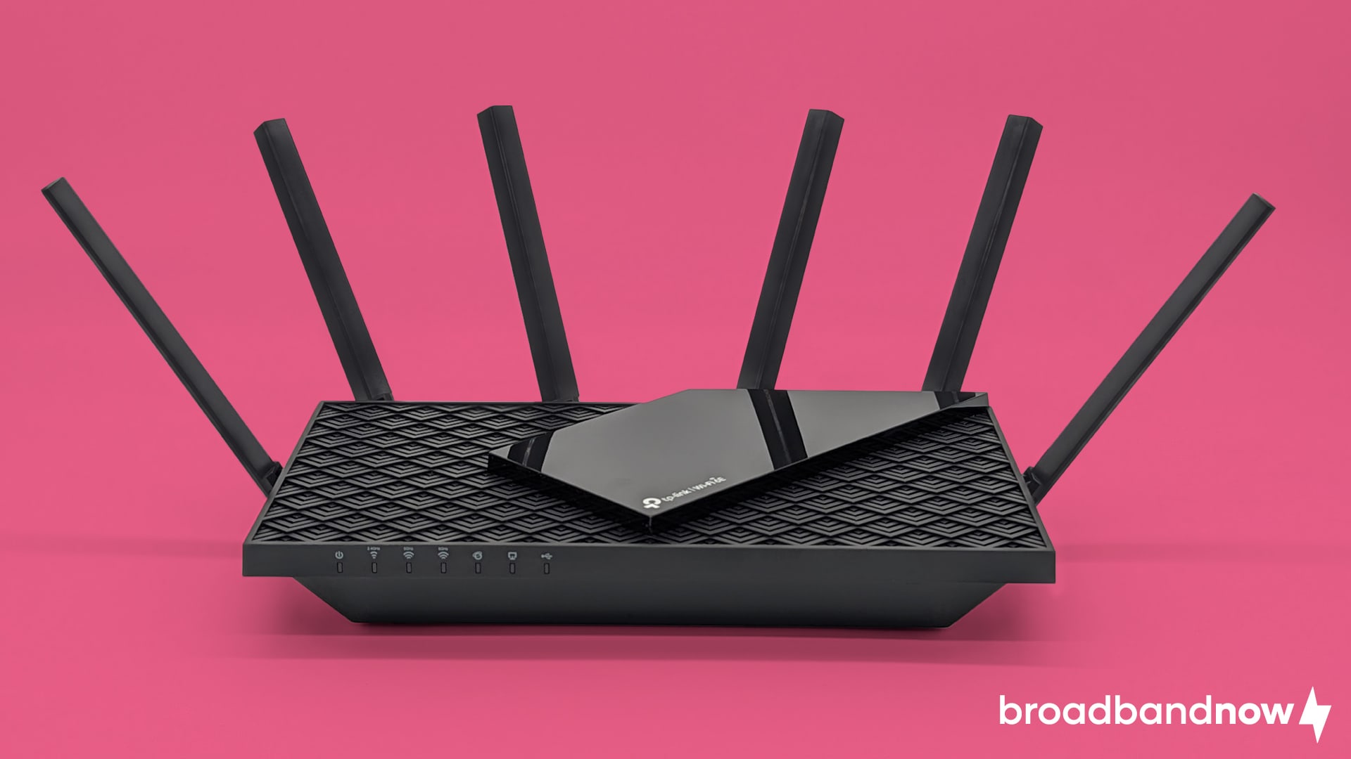 TP-Link AXE75 Wi-Fi router on a pink background