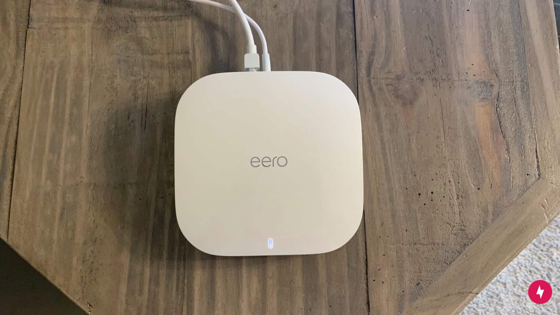 An Eero Pro 6 device plugged in and sitting on top of a cabinet.