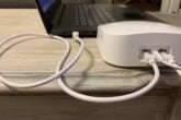 A white Ethernet cord connected to a black Windows laptop and a white Eero router.