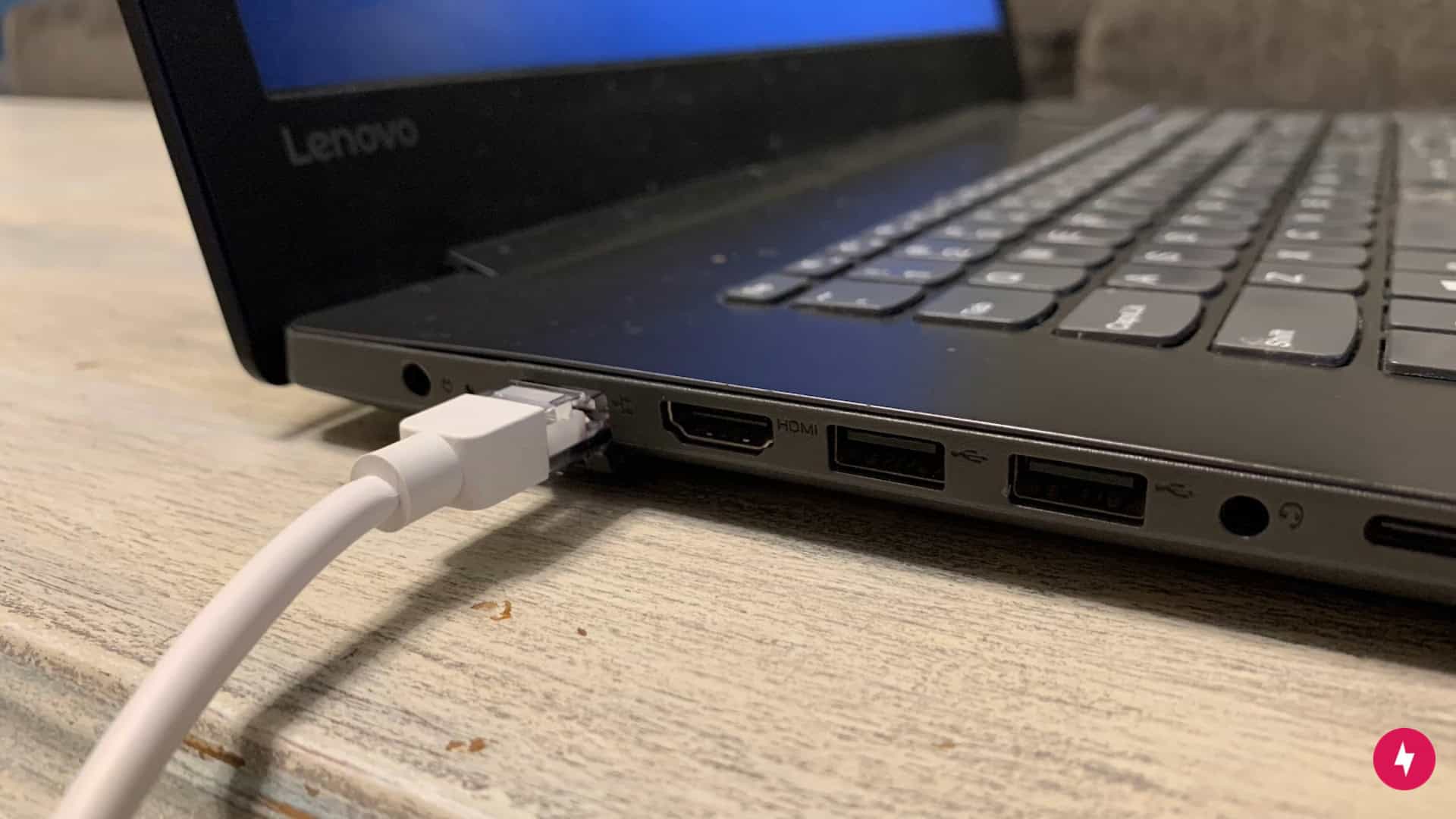 An Ethernet cord connected to a black Windows laptop.