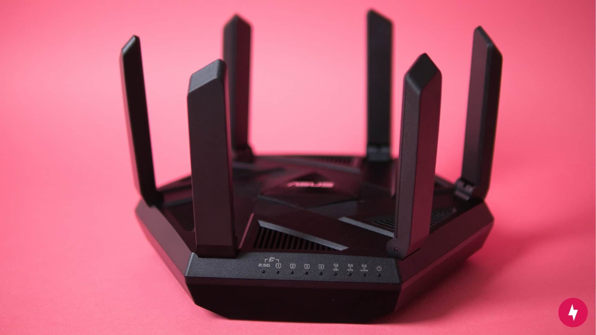The Asus-RT-AXE7800 against a red backdrop.