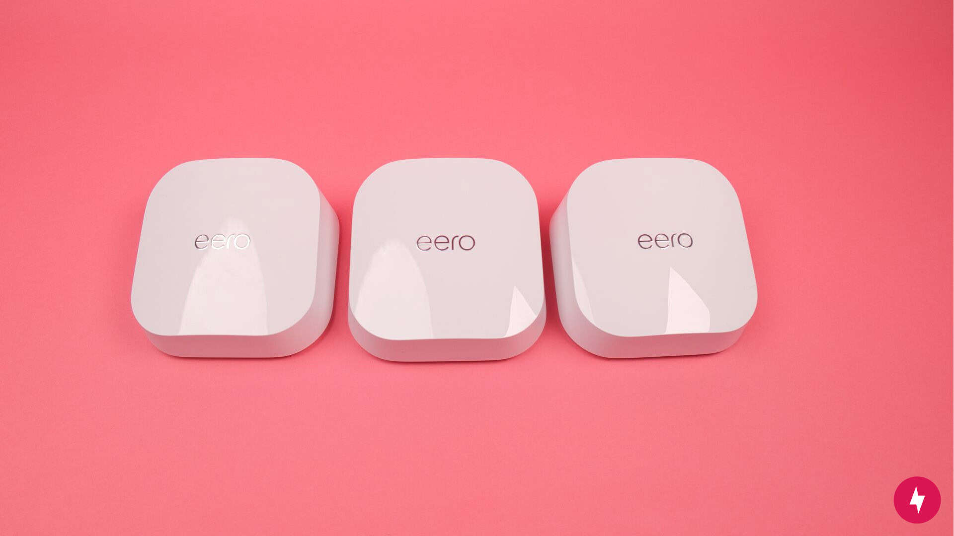 Three eero 7 nodes against a red backdrop.