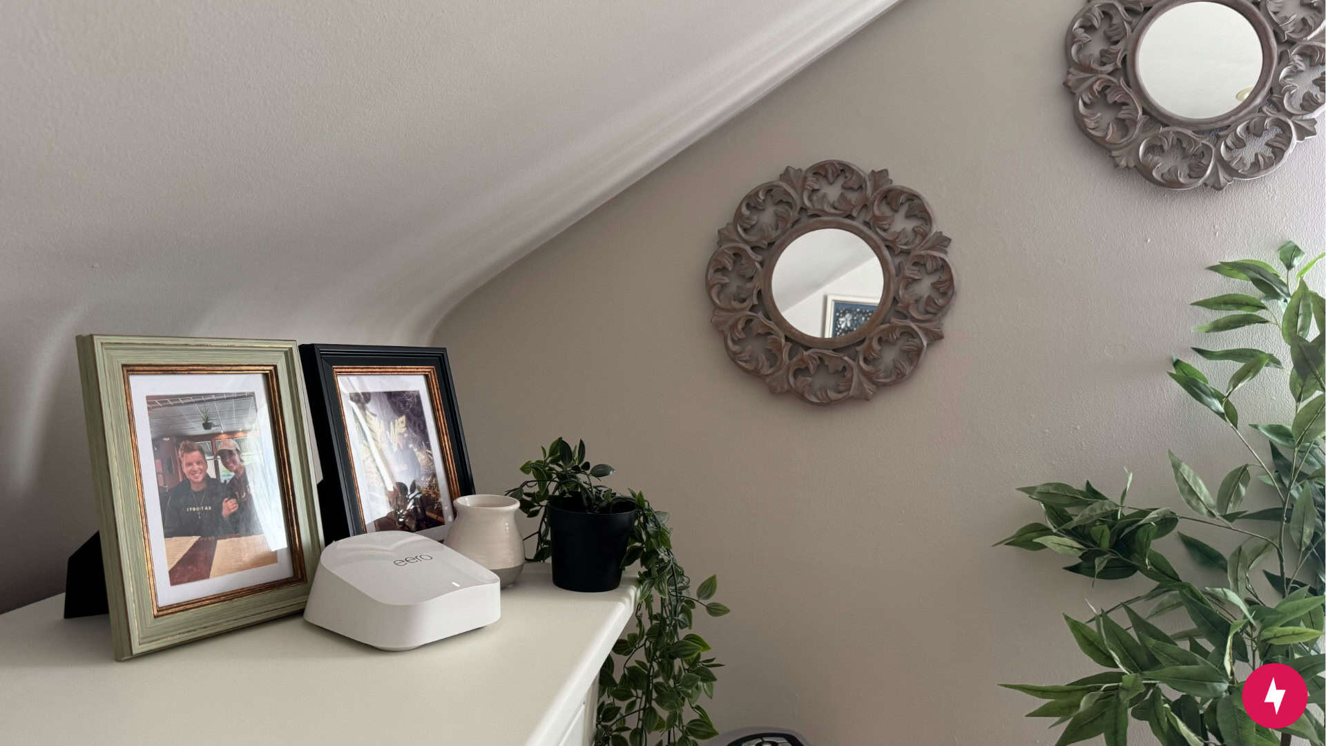 An eero 7 node placed on a shelf next to framed photos.