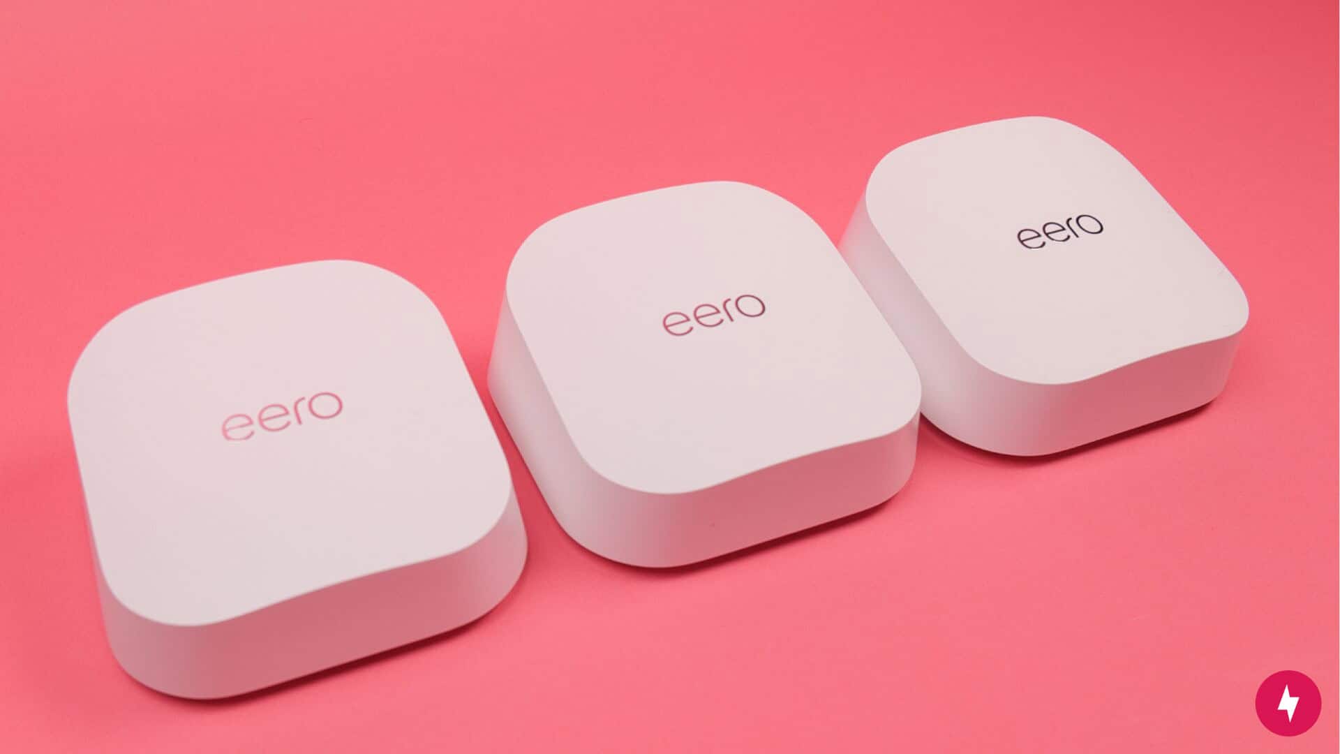 Three eero 7 nodes against a red backdrop.