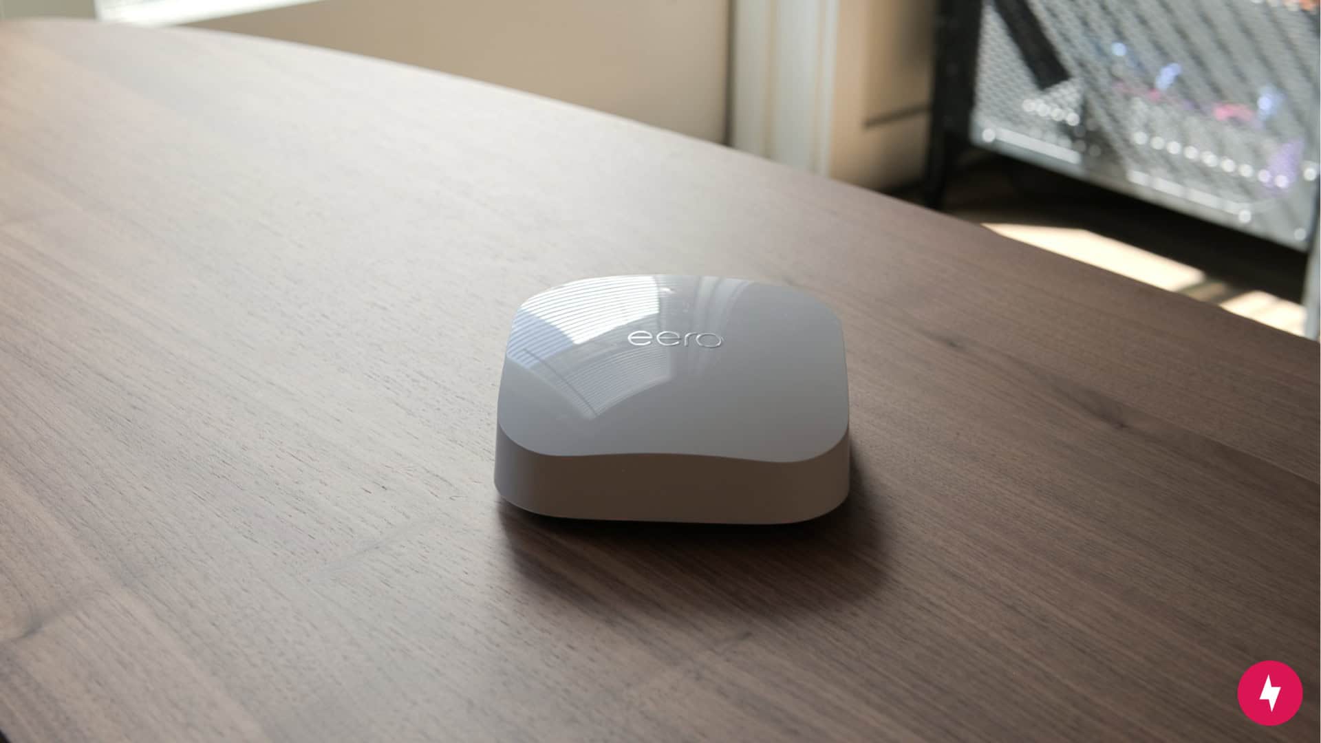 The eero Pro 6E on a wooden table.