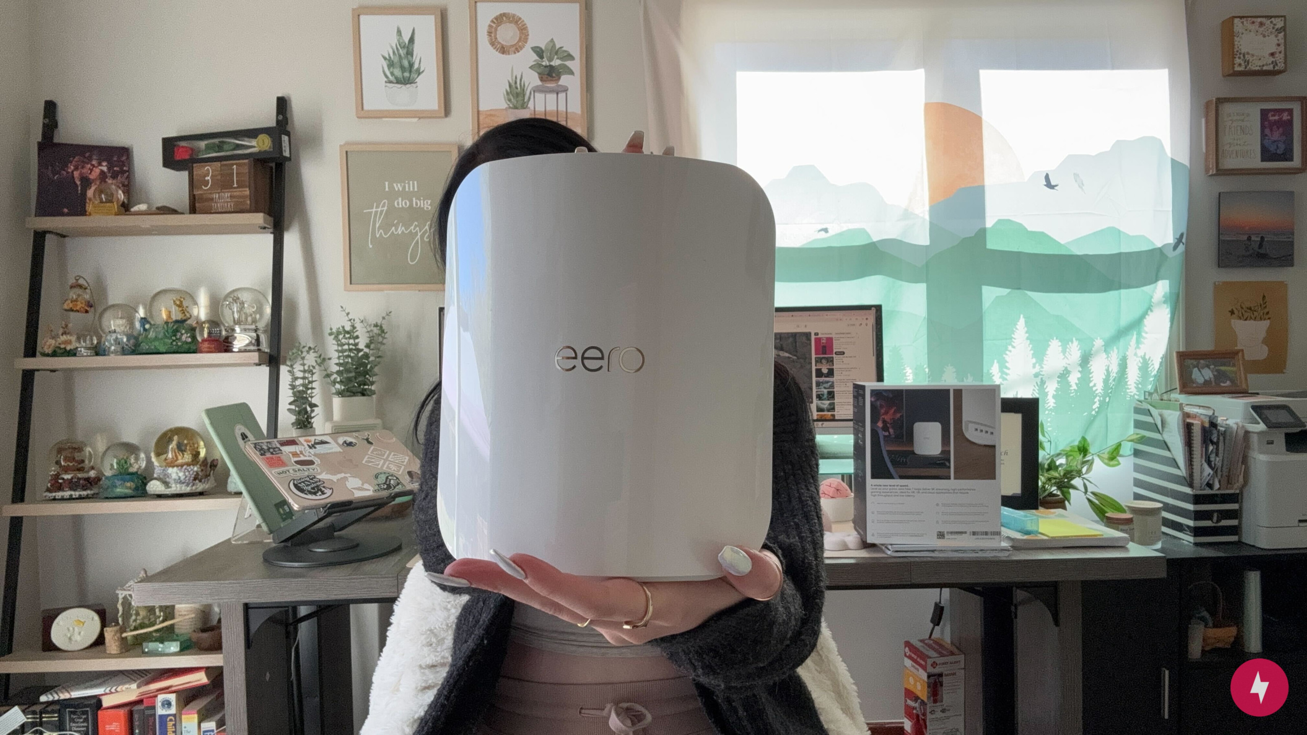 BBN writer Hanna holds the Eero Max 7 device in front of her face.