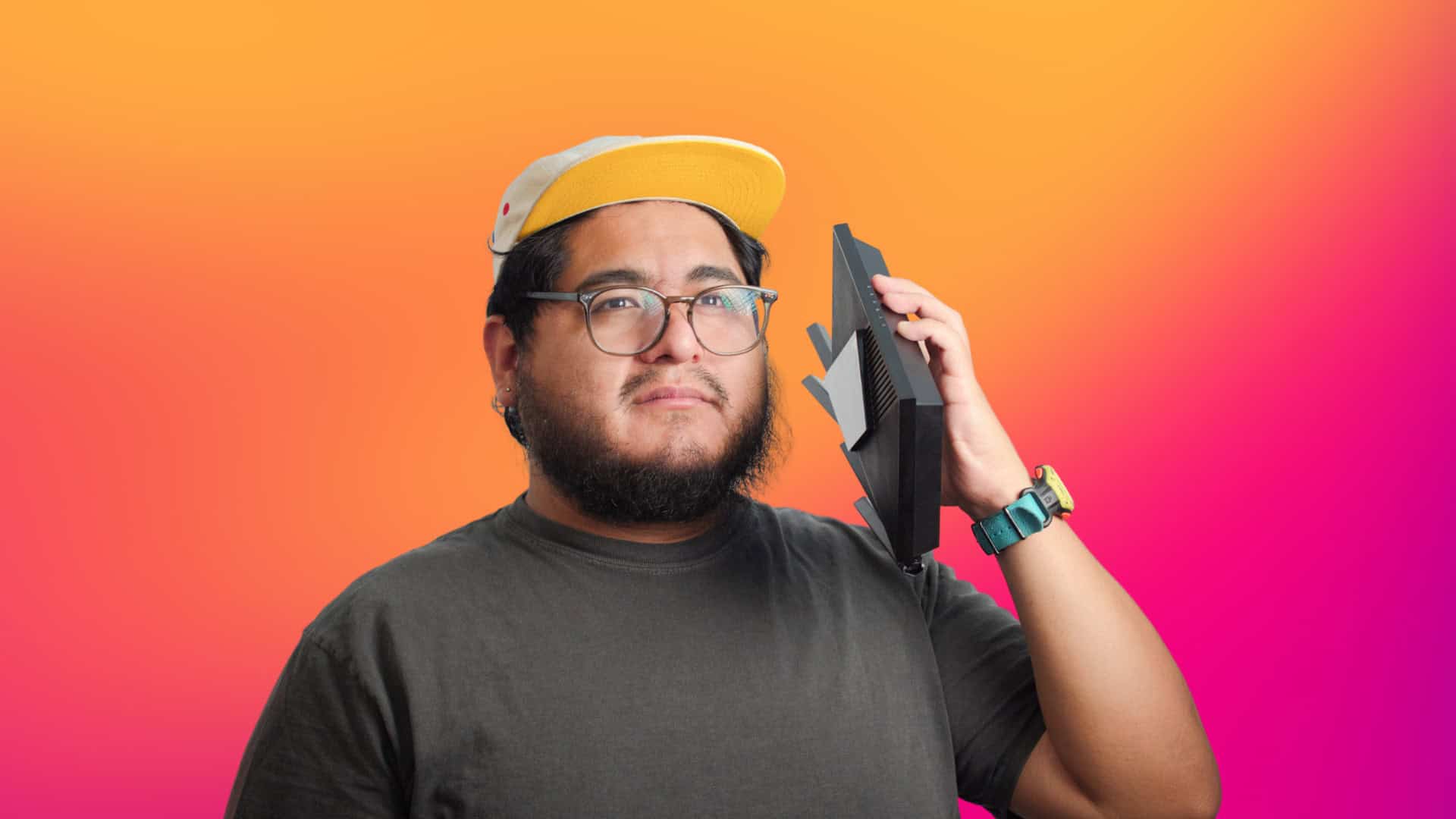 Alejandro Medellin holding a TP-Link router as a phone
